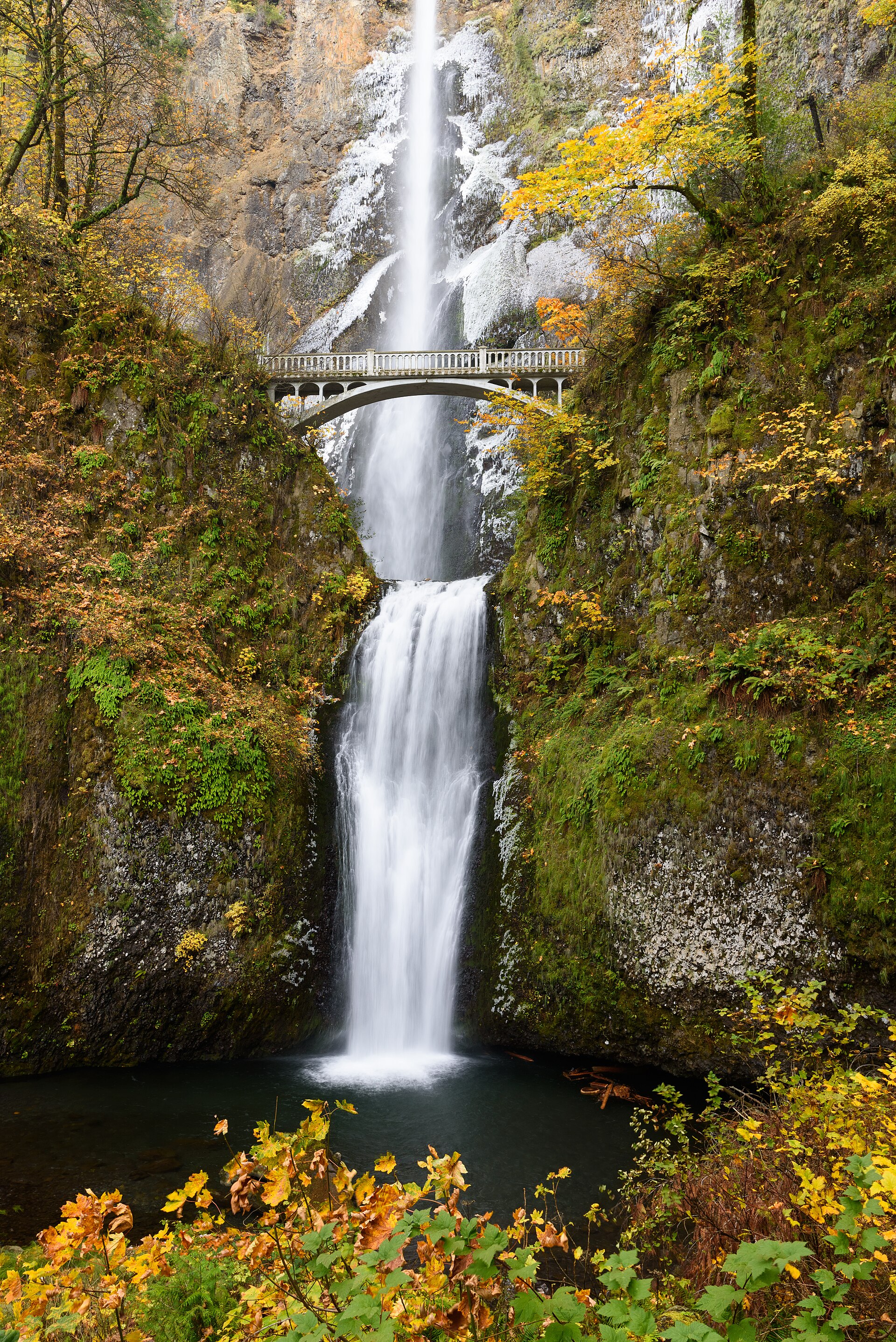 Multnomah Falls pouring over basalt cliffs into its misty pool in the Columbia River Gorge